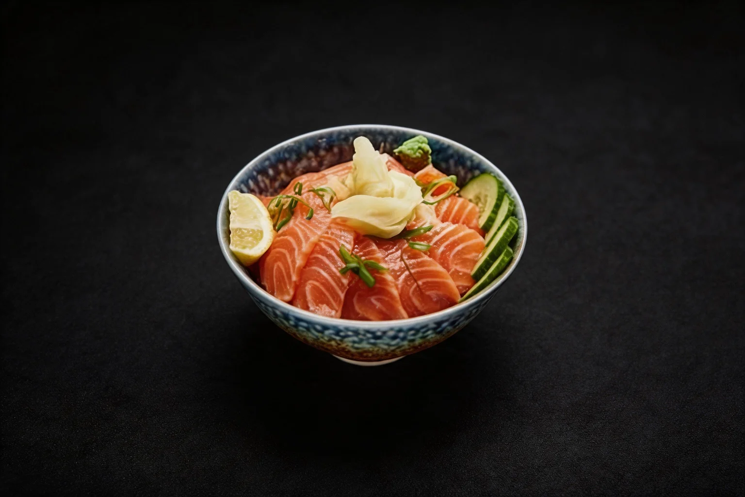 C1. Chirashi saumon dans un bol en céramique bleue, fond sombre.