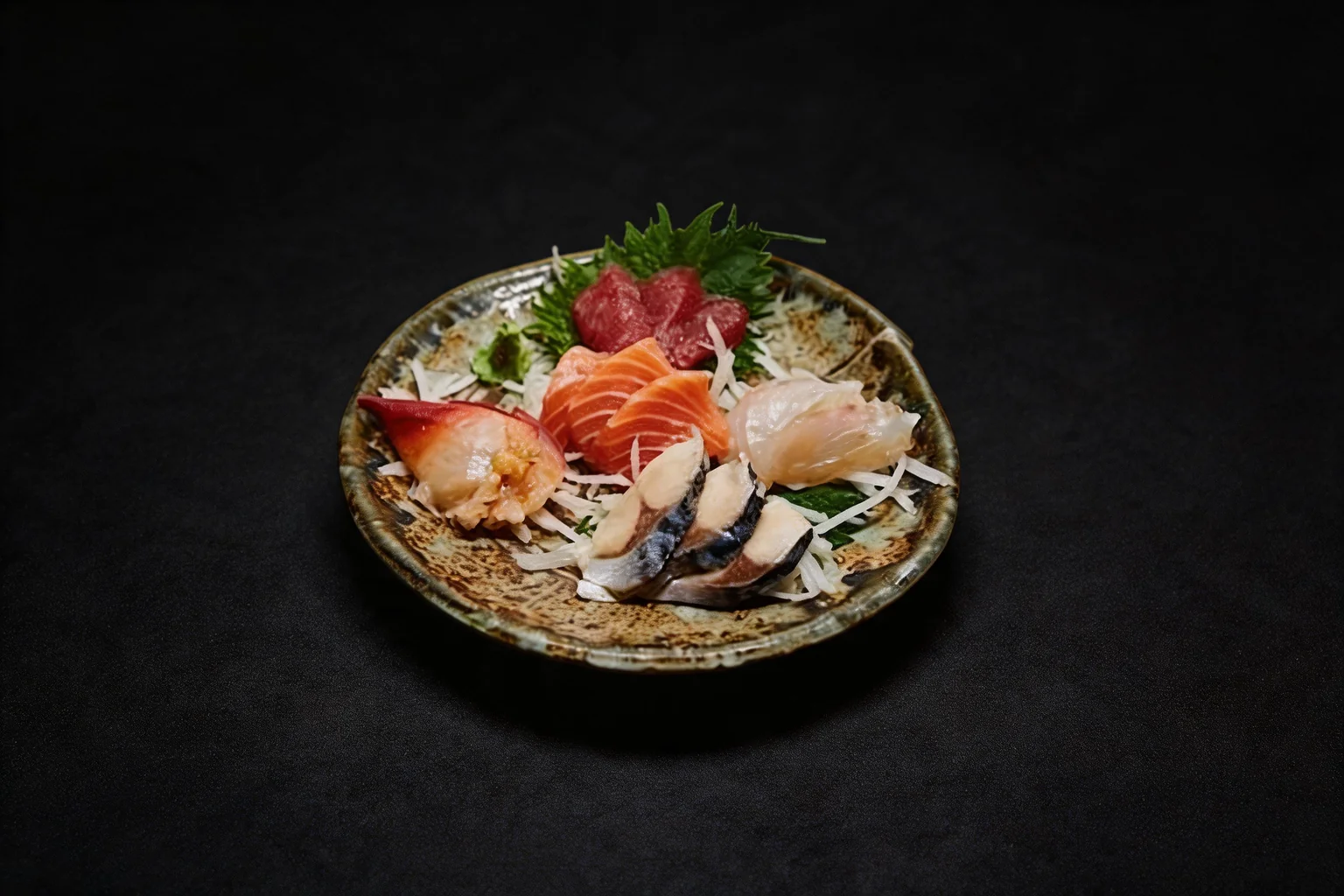 Formule sashimi : sashimis sur une assiette ronde en céramique, fond sombre.