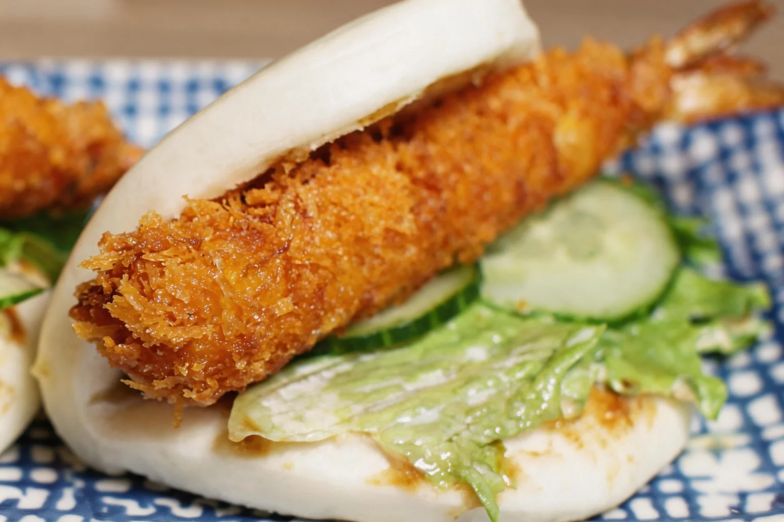 Bao au beignet de crevette sur une assiette bleue et blanche.